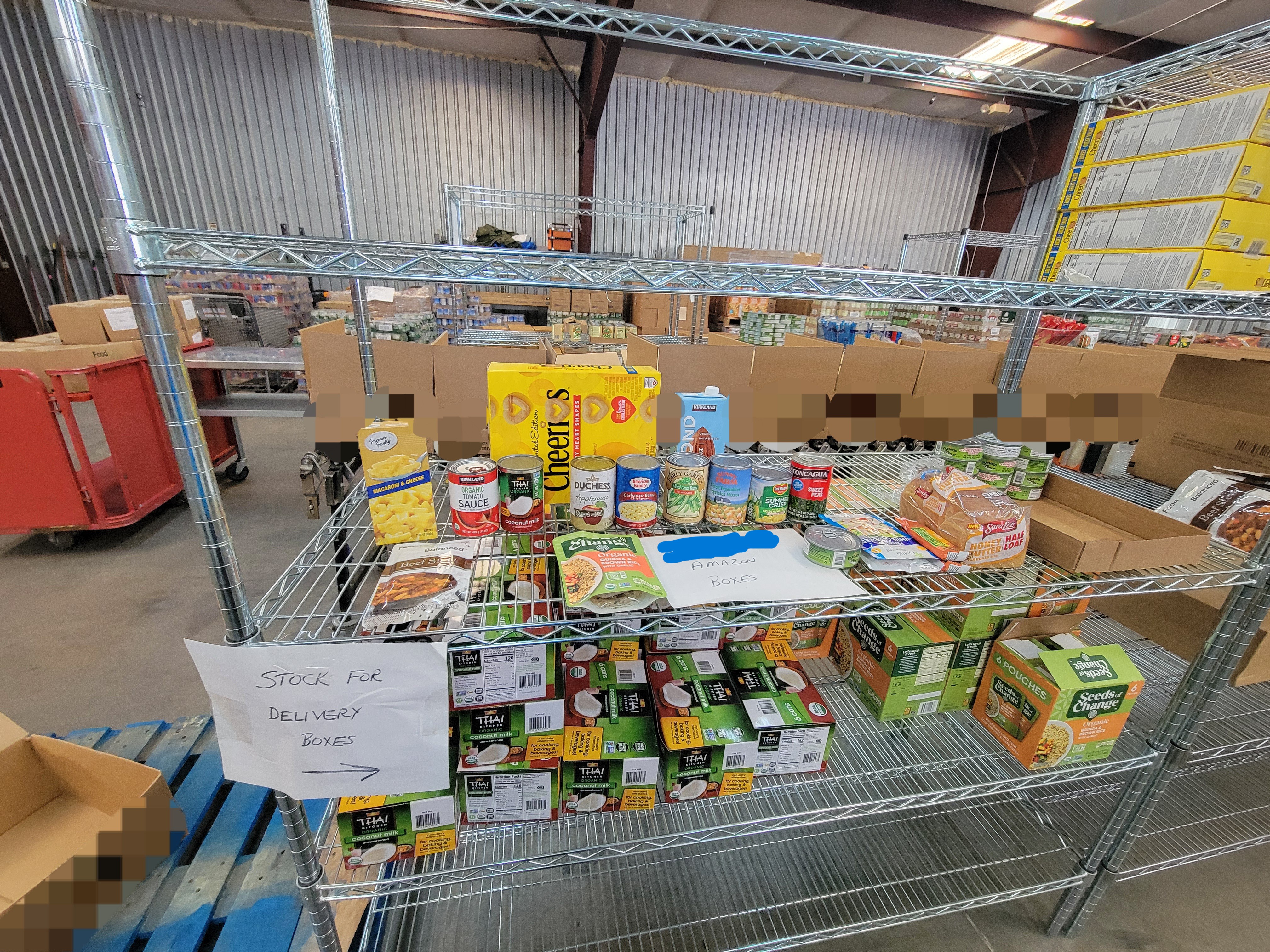 Various dry goods on shelves with boxes on conveyor belt behind it.